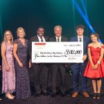 Leaders from the three Minnesota BBBS agencies, as well as two mentees, pose on a stage as they receive a check from the Federated Challenge gala