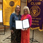 BBBS Executive Director Jackie Johnson and Dr. Perian Stavrum pose in front of the Optimist Club Friend of Youth banner